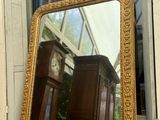 a mirror sitting on a window sill in front of a clock