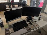 two computer monitors sitting on a desk with a keyboard and mouse