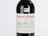 la bouteille de vin rouge est posée sur une surface blanche