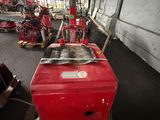 a red machine that is sitting on a pallet in a warehouse
