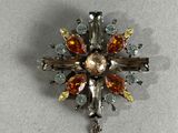 une broche ornée d'une croix en cristaux