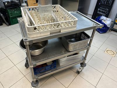 un chariot en métal sur lequel se trouvent plusieurs verres vides
