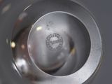 a close up view of a silver vase with a logo on it