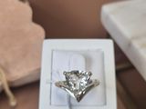 une bague en diamant dans une boîte blanche posée sur une table