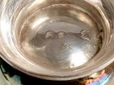 a silver bowl sitting on top of a white table