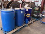 two blue barrels sitting on a pallet in a warehouse