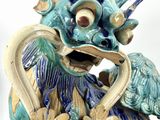 a blue and white dragon statue with flowers on it ' s head