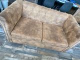 a brown couch that is sitting on a wooden floor