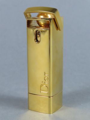 une photo d'un briquet doré posé sur une table blanche