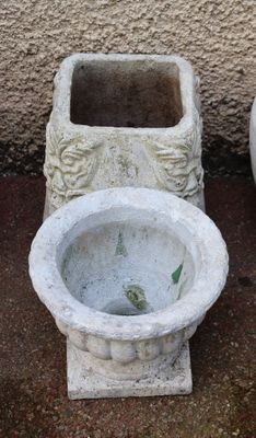 two cement pots sitting next to each other on the ground