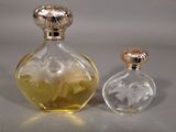 two perfume bottles sitting next to each other on a table