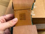 someone is holding a pair of shoes in front of a box