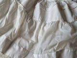 a white blanket on a bed with a white comforter