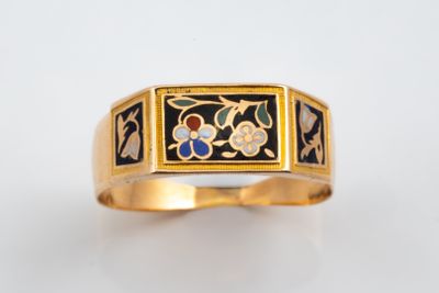 un gros plan d'une bague en or ornée d'un motif floral