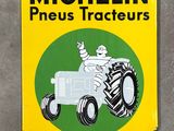 yellow and green sign of a tractor with a man on it