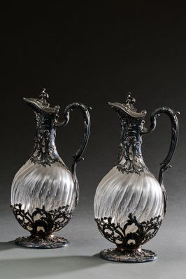 une paire de vases anciens en verre plaqué argent, posés sur une surface grise