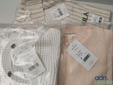 three pairs of sweaters that are wrapped in plastic bags