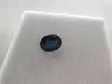 a blue sapphire stone sitting on top of a white surface