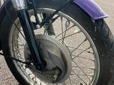 purple motorcycle parked on the side of the road in a parking lot