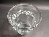 a glass of water sitting on a table next to a spoon