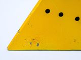 a yellow triangle with holes in it on a white surface