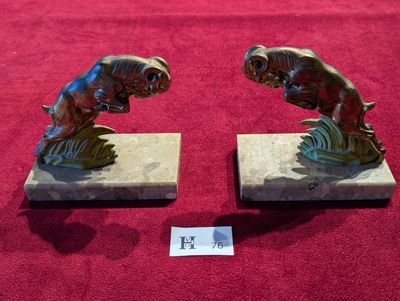 paire de serre-livres en bronze représentant des poissons, posés sur des socles en marbre, sur fond rouge