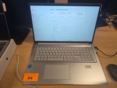 un ordinateur portable posé sur un bureau avec une souris