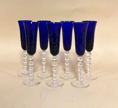 quatre verres à vin bleus posés les uns à côté des autres sur une table