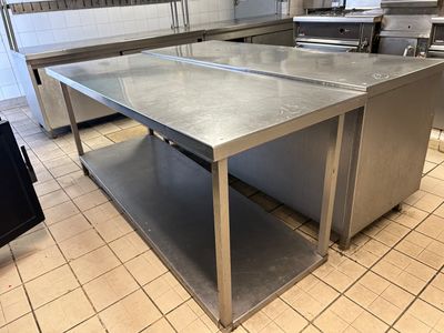 un grand îlot de cuisine en inox au milieu de la cuisine