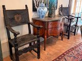 deux chaises et une table dans une pièce où est accroché un tableau au mur