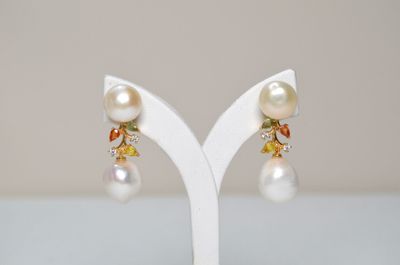 a close up of a pair of earrings on a white stand