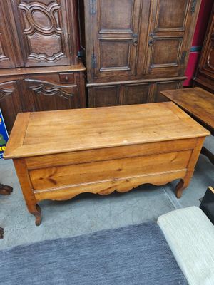 un coffre en bois posé par terre à côté d'une chaise