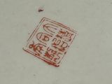 a red stamp on the side of a white plate