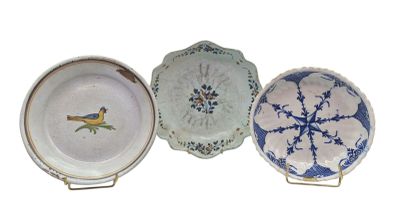 three plates with blue and white designs on them on a stand