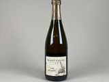 une bouteille de vin posée sur une table blanche