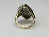 a close up of a gold ring with a black stone on it