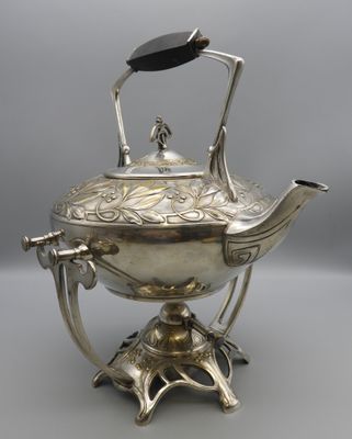 a silver teapot on a stand with a black handle