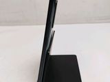 the back of a black cell phone sitting on top of a black stand