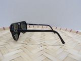 a pair of black sunglasses sitting on a wicker basket