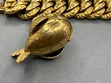 a gold necklace with a turtle on it and a chain around it