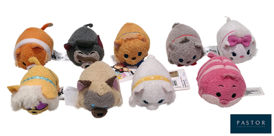 Plusieurs petites peluches sont alignées en rang sur une surface blanche