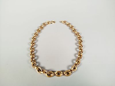 a close up of a gold chain necklace on a white surface