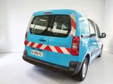 a blue van with red and white stripes parked in a white room