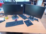 two computer monitors sitting on a desk with a keyboard and mouse