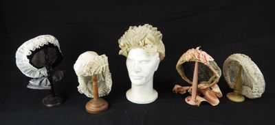 trois chapeaux et un porte-chapeaux sur fond noir