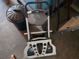 une personne debout à côté d'une chaise sur laquelle est posé un ventilateur