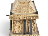 an image of a gold casket sitting on top of a white surface