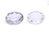 un gros plan sur deux boutons en verre transparent posés sur une surface blanche