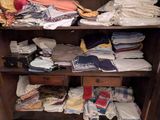 une armoire sur laquelle sont posés de nombreux vêtements pliés