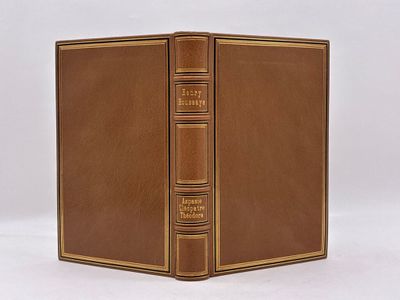 un vieux livre à la couverture marron posé sur une table blanche